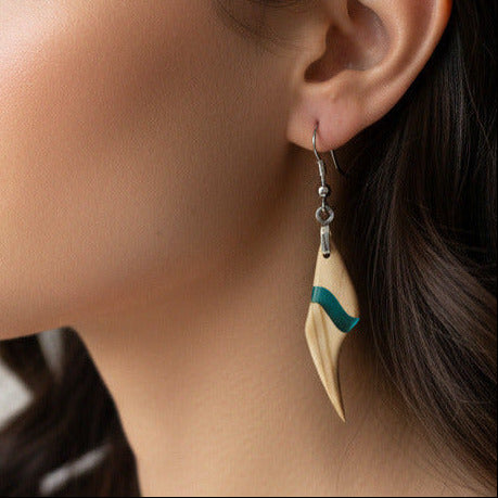 modelo lleva puesto pendiente elaborado en madera olivo con resina de azul turquesa translúcido, con fornitura de metal de acero inoxidable 316