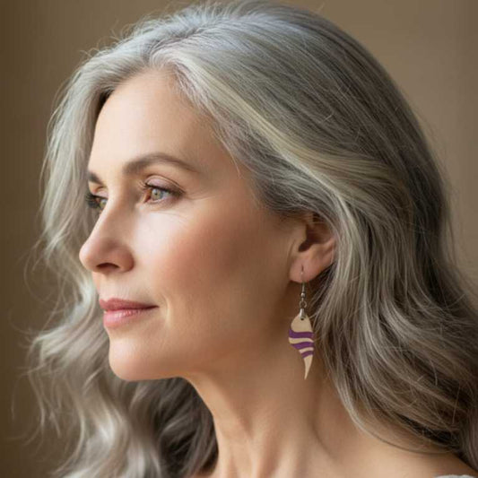 modelo de 60 años lleva puesto pentientes de madera de ciprés y resina rosa mate.