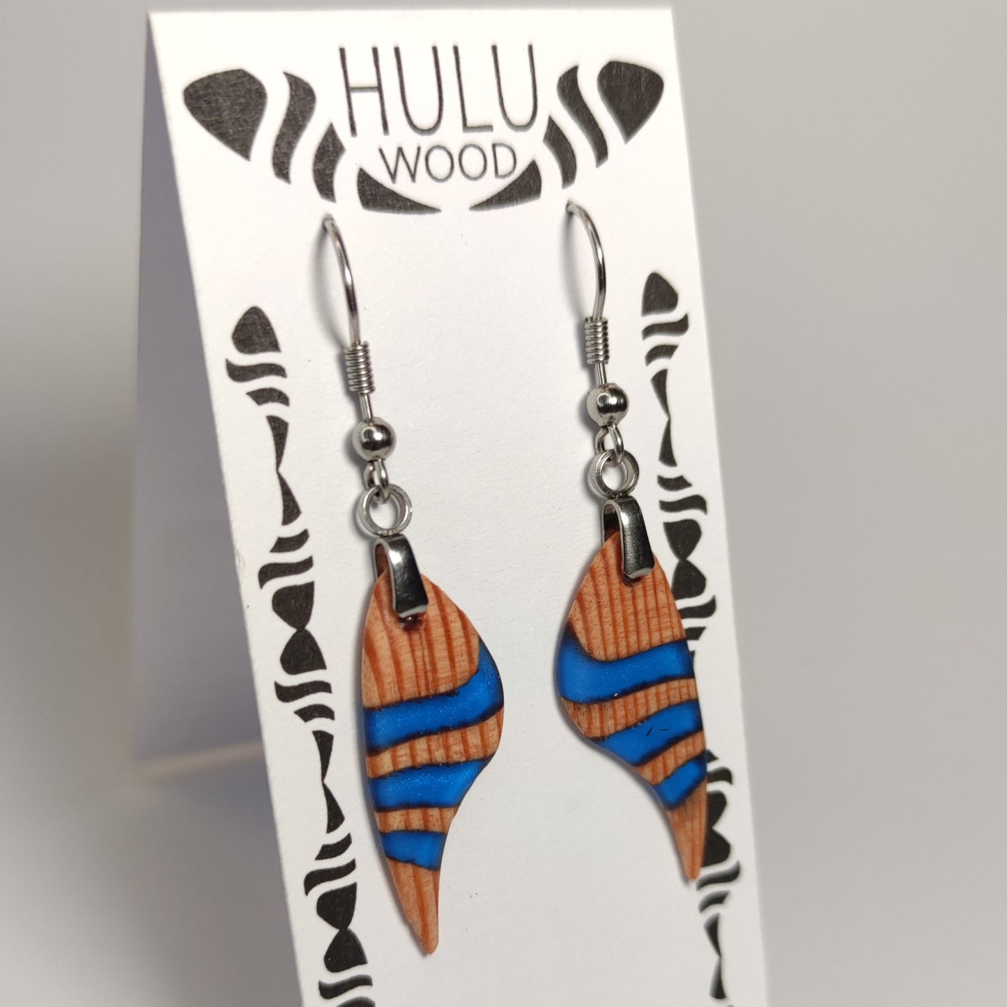 A1 pendientes HuluWood cedro azul marino mate en su expositor oblicuo