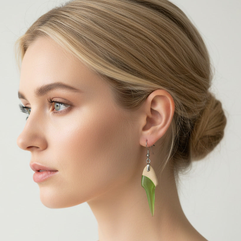 mujer lleva puesto pendiente de madera y resina color verde pistacho transparente con fornitura metálica de acero inoxidable.