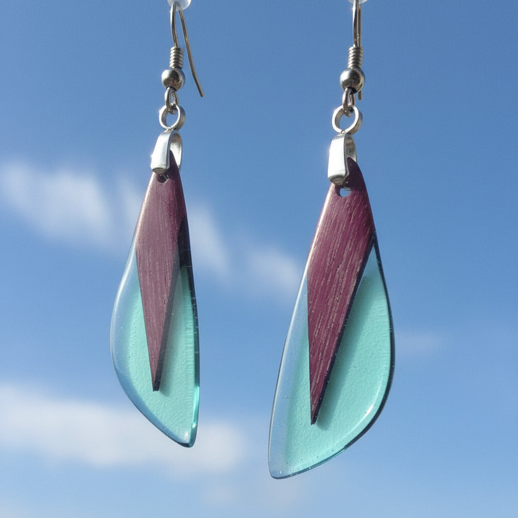 pendientes de madera amaranto y resina azul claro translúcida, con forma gota puntiaguda, y fornitura metalica acero inoxidable.
