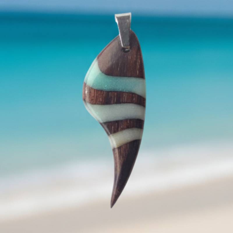colgante de madera pauferro  resina opaca blanco y azulado opaco sobre fondo de mar azul del caribe
