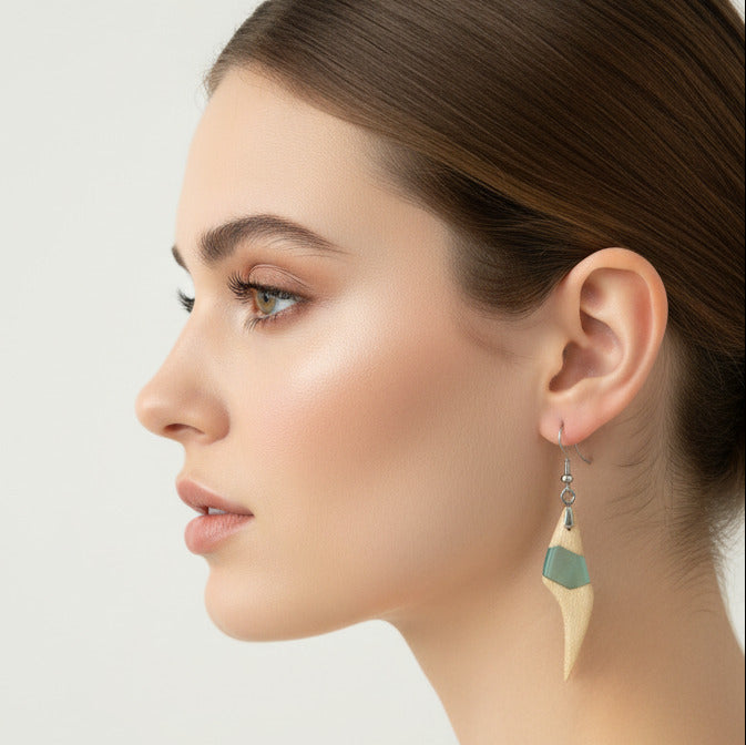 modelo que lleva pendientes de gancho en madera de arce claro y resina azul claro translúcido.