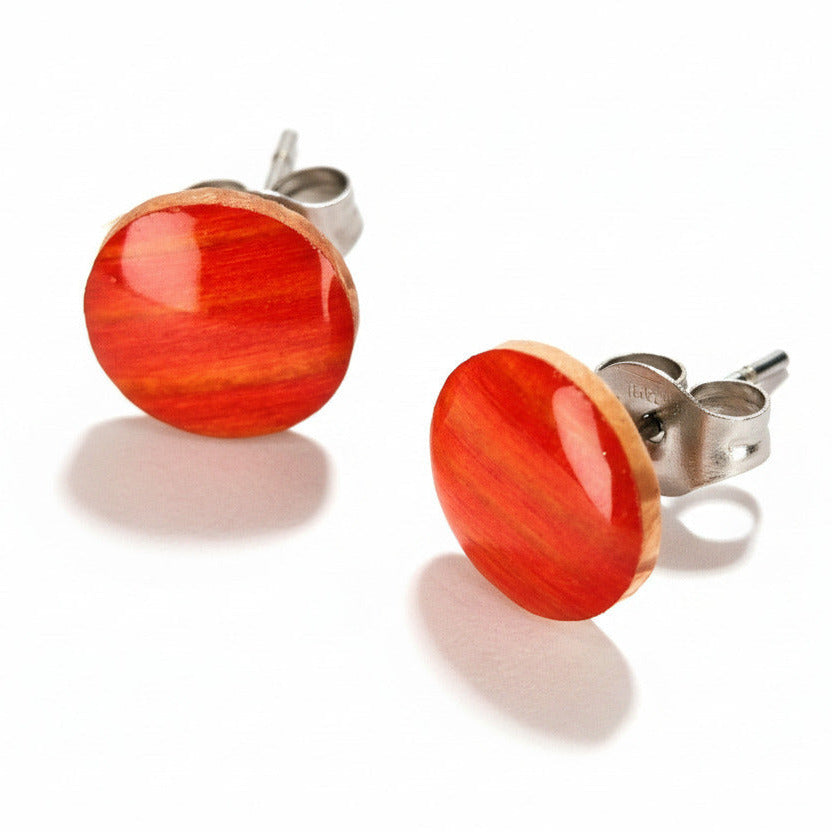 pareja de pendientes de botón circulares 9mm elaborados en pino con acabado naranja veteado brillante colocados 
sobre fondo blanco